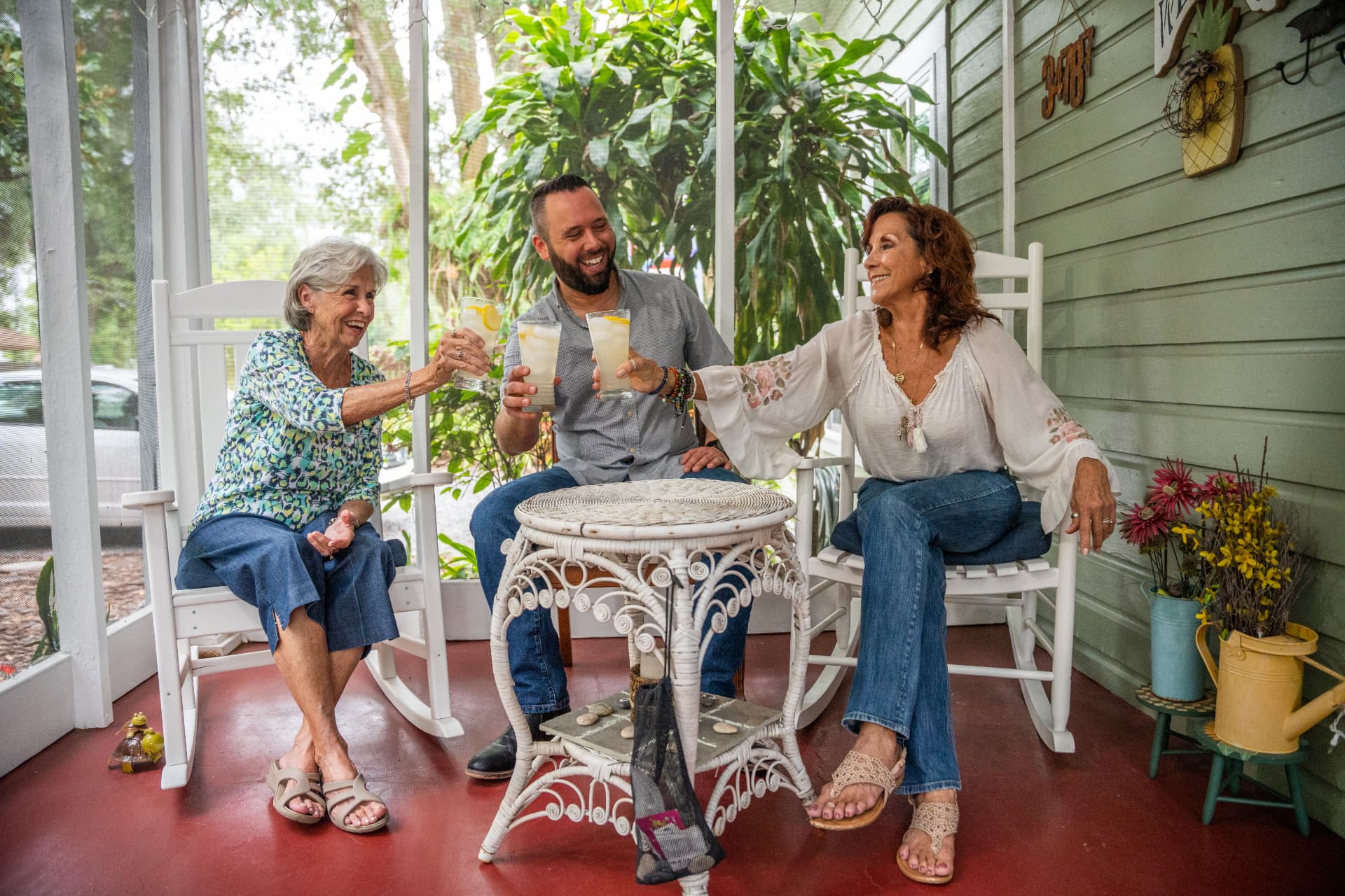 Austin Arthur sharing lemonade with two longtime West Orange County residents on a historic front porch